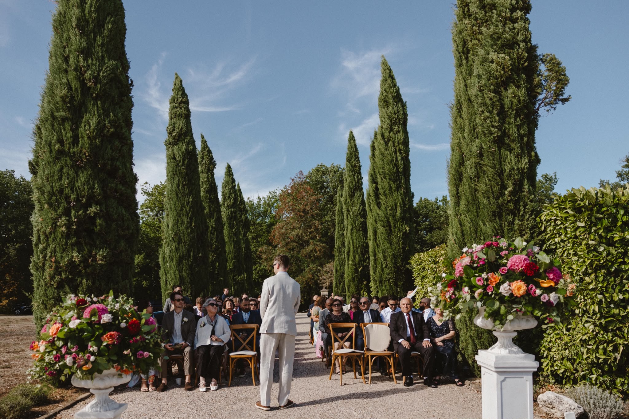 Ceremony with guests seated in front of colourful flowers