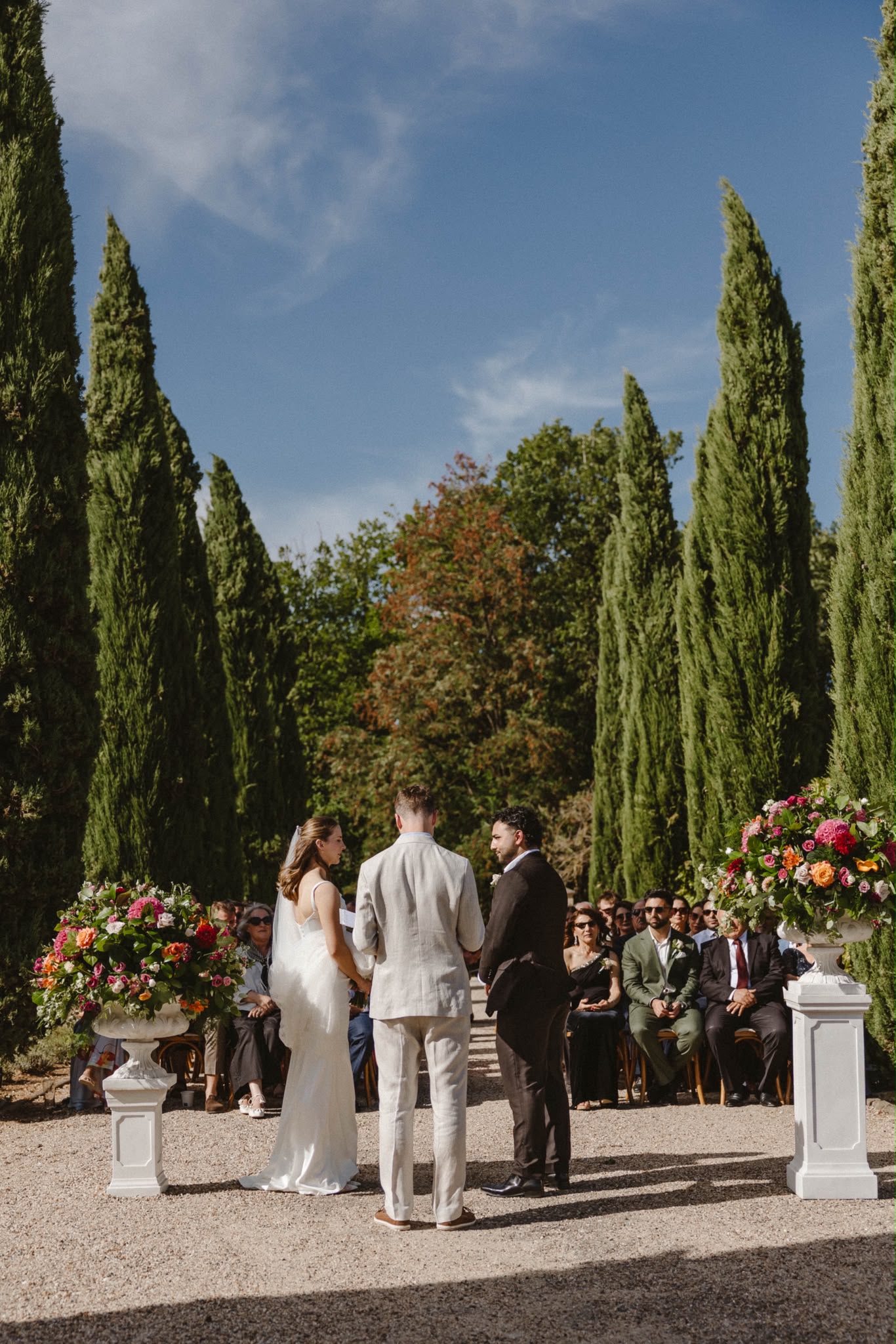 Ceremony among cypress trees with floral urns