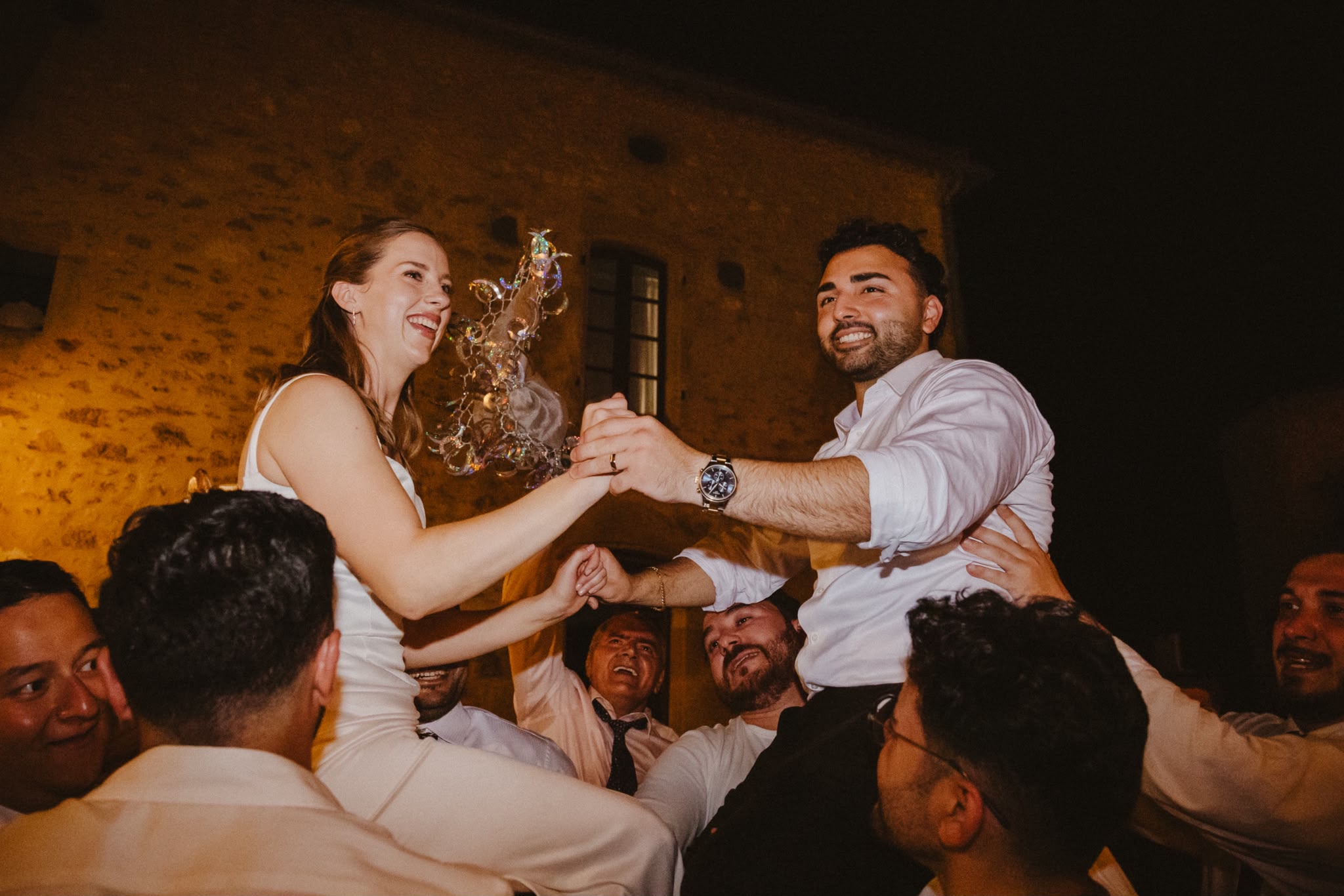 Guests lifting the couple during the evening celebration