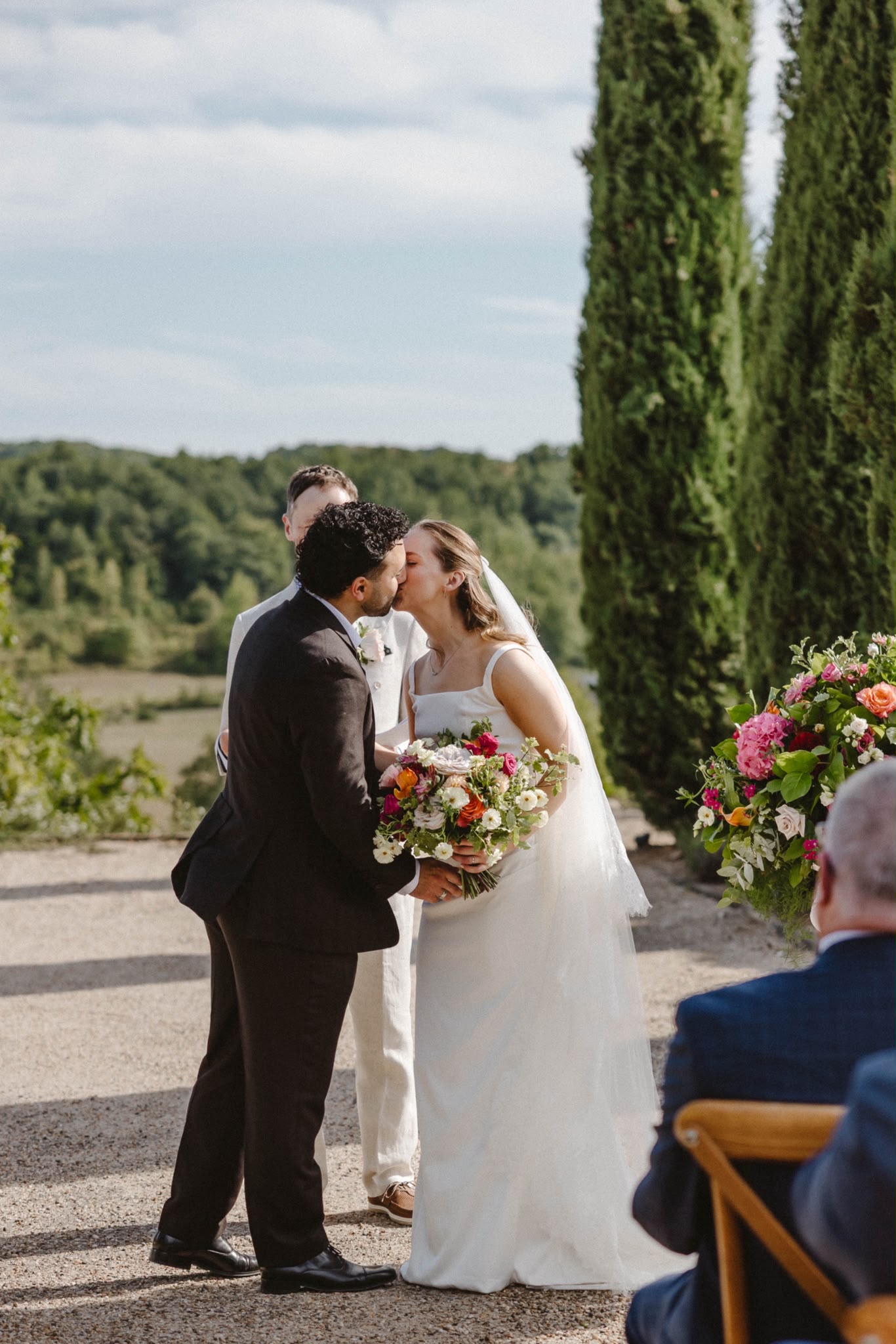 Couple's first kiss with the vineyards behind
